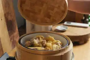 Steamed Aurum Cockerel pieces in a bamboo steamer